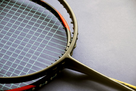 Badminton rackets on badminton indoor court floor, the upper racket is broken and has no string,...