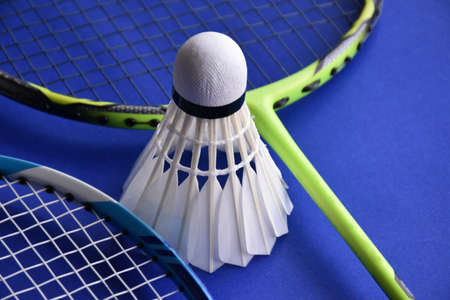 Cream white badminton shuttlecocks and racket s on blue floor of indoor badminton court, soft and selective focus, copy space.の写真素材