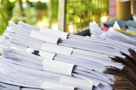Used white paper is bundled together in piles infront of the bulcony to be sold or made into...