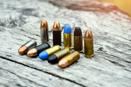 9mm ammunitions or bullets for practice shooting on gray wooden background, soft and selective focus.の写真素材
