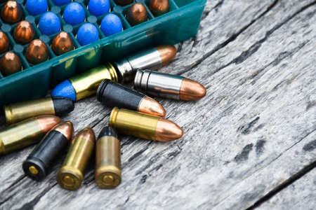 9mm ammunitions or bullets for practice shooting on gray wooden background, soft and selective focus.の写真素材