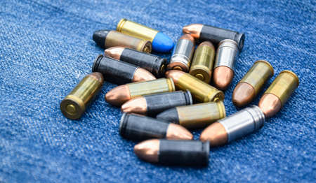 9mm pistol bullets for shooting training and camping on blue jeans, soft and selective focus on...