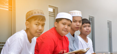 Portrait asian muslim or islamic boys sitting with muslim boys in a row to pray or to do the...