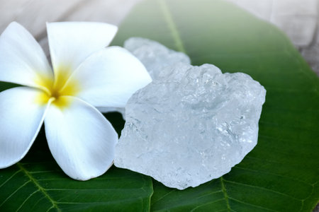 Alum cubes on ceramic pot and plumeria flowers background, concept for herb, bodycare, skincare, waterclear, spa, treatment, disease protection and protect armpit smell.の写真素材