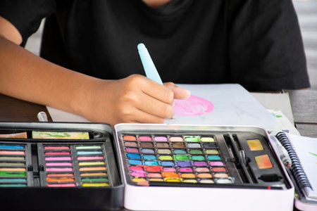 Close-up of a young boy drawing with crayons.の写真素材