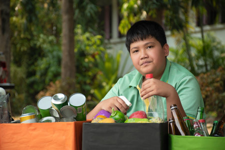 Boy sorting plastic waste in the garden. Plastic waste recycling concept.の写真素材