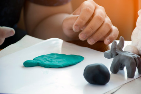 An autistic boy molding different shapes of colored plasticine at home to develop slower brain than normal children.の写真素材