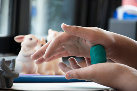 Children's hands playing with plasticine in the classroom. Education concept.の写真素材