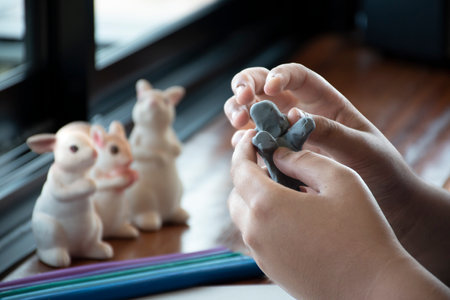 An autistic boy molding different shapes of colored plasticine at home to develop slower brain than...