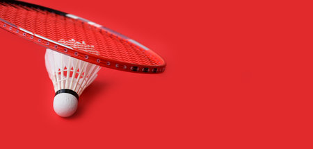Badminton racket and shuttlecock on a red background with copy spaceの写真素材