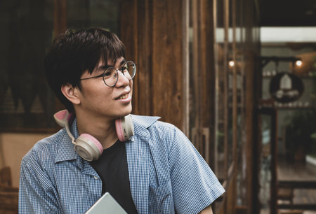 Young man with headphones and laptop in a coffee shop. Asian peopleの写真素材