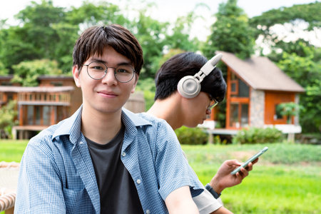 Young asian man listening to music with headphone in the garden.の写真素材