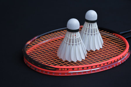 Badminton rackets and shuttlecocks isolated on black backgroundの写真素材