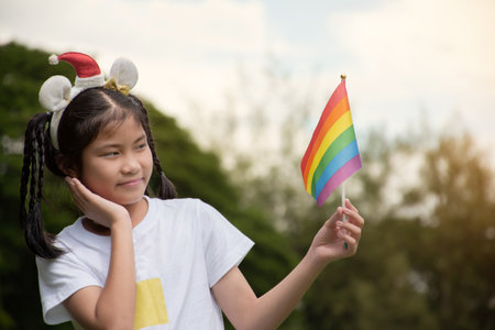 Little asian girl holding lgbt flag in the park.の写真素材