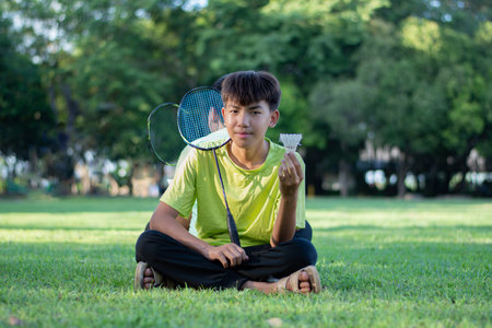 Young asian man playing badminton in the public park.の写真素材