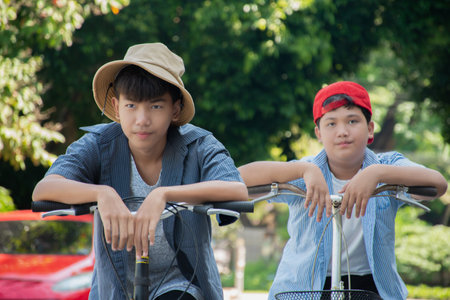 Young asian man and woman riding bicycle together in the park.の写真素材