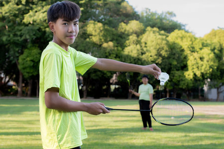 Portrait of young man playing badminton in the park.の写真素材