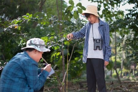 Farmer and gardener are checking quality of fruit trees in the garden.