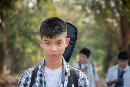 Portrait of a young asian boy with backpack in the parkの写真素材