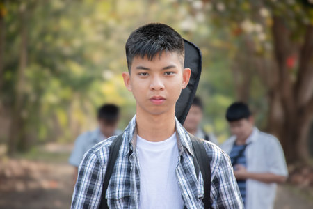 Portrait of asian boy with backpack standing in the park.の写真素材