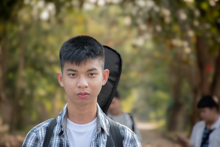 Portrait of a young Asian man with backpack in the park.の写真素材