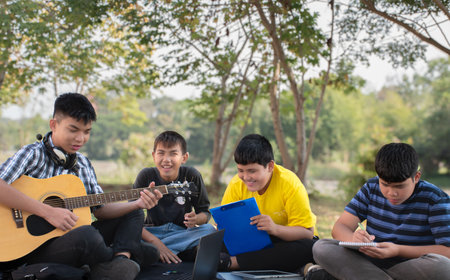 Group of young students playing guitar in the park. Education concept.の写真素材