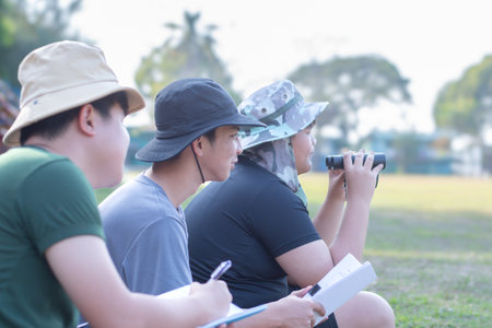 Asian preteens spending their freetimes and doing recreational activity by watching birds in late...