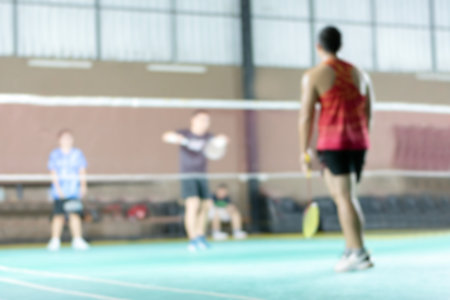 Blurred image of badminton sport playing in indoor badminton court, sport background concept.の写真素材