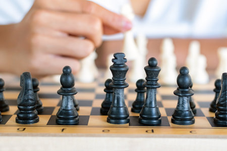 Close-up of boy playing chess with his friend in the roomの写真素材