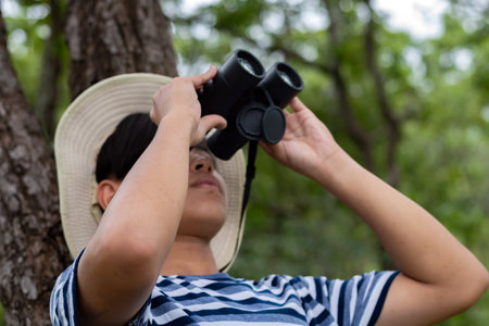 Asian man looking through binoculars in the park, vintage toneの写真素材