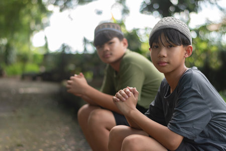 Asian boy sitting on the ground in the park. Selective focus.の写真素材
