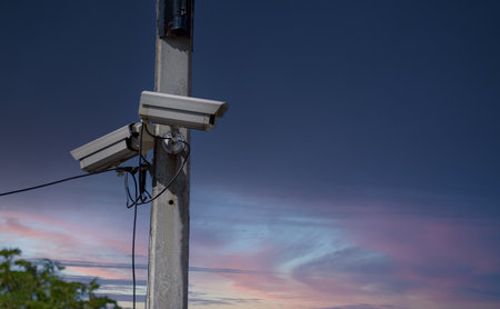 Surveillance camera on the electric pole with blue sky background.の写真素材