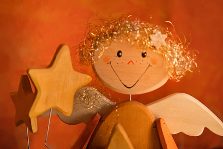 Christmas decoration with angel and wooden stars on orange background. Close up.の写真素材
