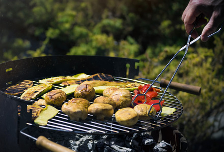 Grilling vegetables on chargrill. Barbecue. Cooking vegetables on the grill pan in a herb marinade, top view. Delicious vegetable barbecue on grill.の写真素材
