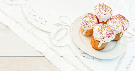 Happy Easter cake with sprinkles on white glaze. Cake on white rustic board, lace cloth. Homemade...