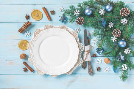 Christmas light blue table setting, menu concept. Pine tree branches, blue silver baubles, stars,...