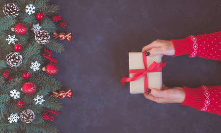 Christmas dark grunge background, festive decoration, woman hands in red pattern pullover with craft...