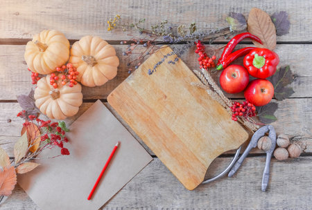 Autumn background, fallen leaves, fruits, vegetables on rustic wooden table. Seasonal set, aged vintage paper, copy space. Thanksgiving food, healthy and fresh, top view, flat lay.の写真素材