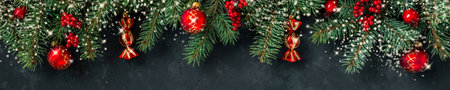 Christmas dark grunge horizontal background, top view. Fir twigs, red golden berries, baubles. Winter holidays, New Year decoration, pine tree branches, snow covered cones, flat lay, copy space.の写真素材