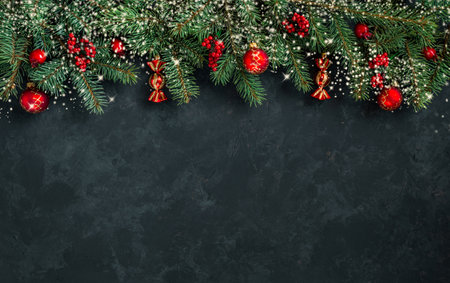 Christmas dark grunge horizontal background, top view. Fir twigs, red golden berries, baubles. Winter holidays, New Year decoration, pine tree branches, snow covered cones, flat lay, copy space.の写真素材