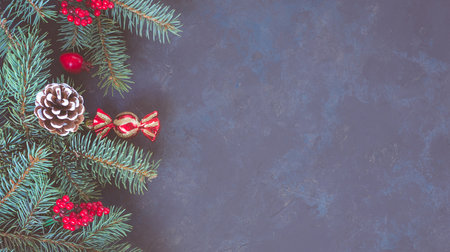 Christmas dark lilac grunge horizontal background, top view. Fir twigs, red golden berries, baubles. Winter holidays, New Year decoration, pine tree branches, snow covered cones, copy space.の写真素材