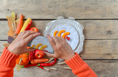 Autumn background, fallen leaves, fruits, vegetables, rustic wooden table. Hands taking photo with mobile phone. Seasonal set, pumpkins, corn cobs, wheat. Thanksgiving food, healthy, fresh, top view.の写真素材