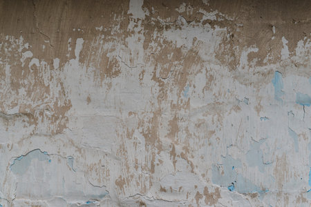 Weathered cracked plaster background. Damaged wall texture with peeling paint, shabby vintage rustic surface.の写真素材