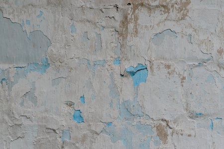 Weathered cracked plaster background. Damaged wall texture with peeling paint, shabby vintage rustic surface.の写真素材