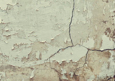 Weathered cracked plaster background. Damaged wall texture with peeling paint, shabby vintage rustic surface.の写真素材