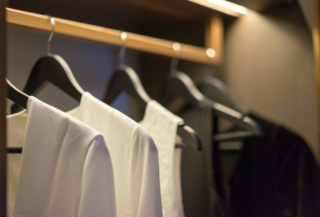 Black and white color tone clothes hanging on rail in a wardrobe, interior design. Interiors.の写真素材
