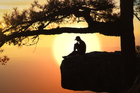 Beautiful views of the sunset with reflect silhouette of the pine tree and male tourist.