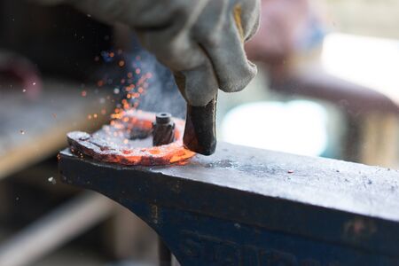 Blacksmiths working in the forge and making a horseshoe.
