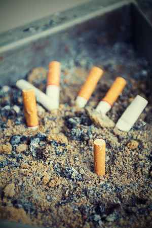 Cigarette butts discarded in ashtray ,vintage toneの写真素材