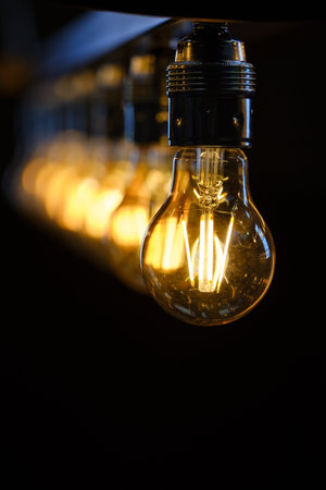Incandescent light bulb on black background with shallow depth of field